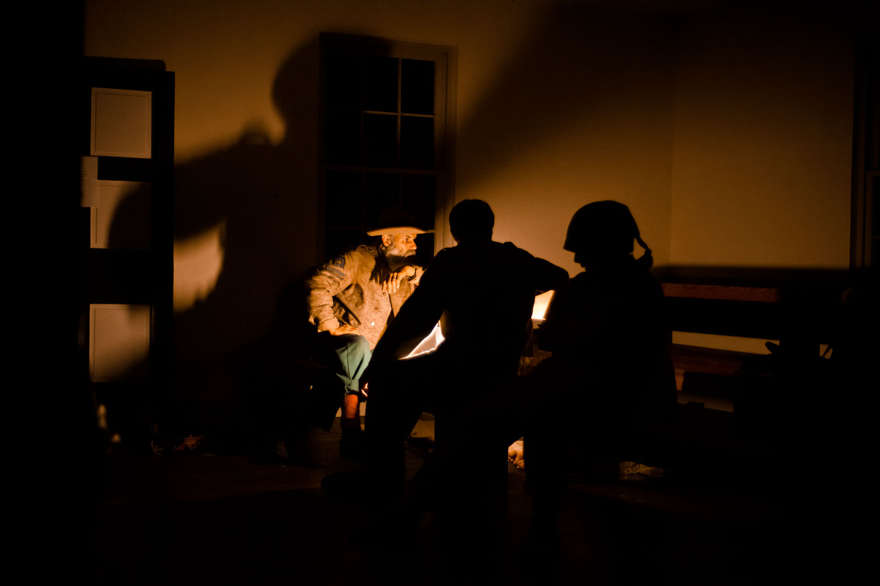 Civil War reenactors at Antietam: men sit by candlelight before spending the night in historic Dunker Church