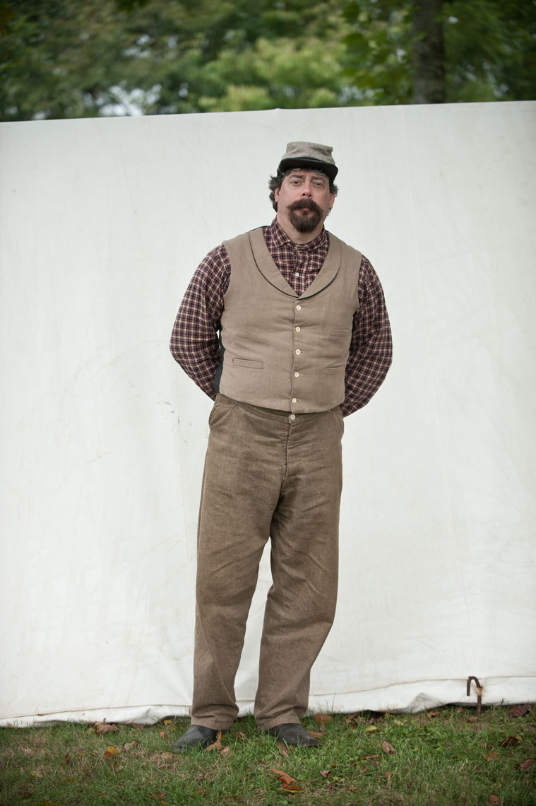 Civil War reenactors at Antietam: a reenactor in a plaid shirt stands next to a tent