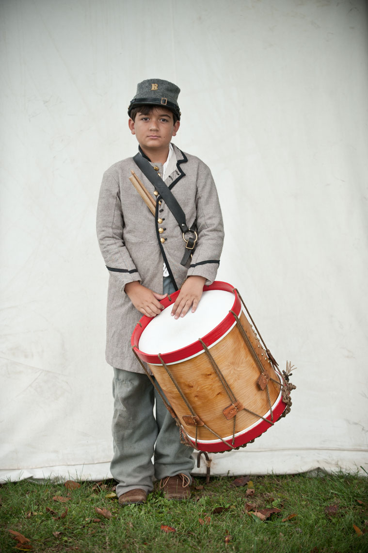 Civil War reenactors at Antietam: a drummer boy stands with his drum
