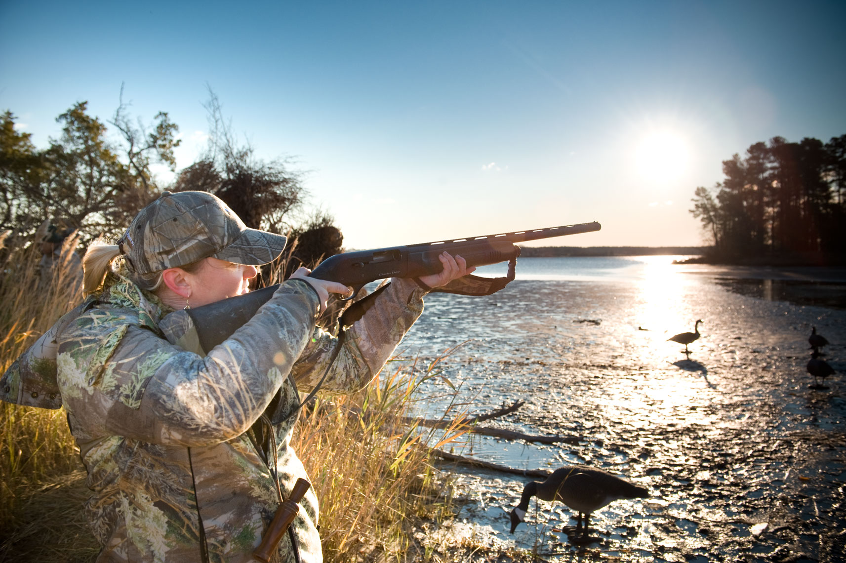 Hunting for waterfowl on the Eastern Shore of Maryland: a female hunter takes her shot into the sunrise