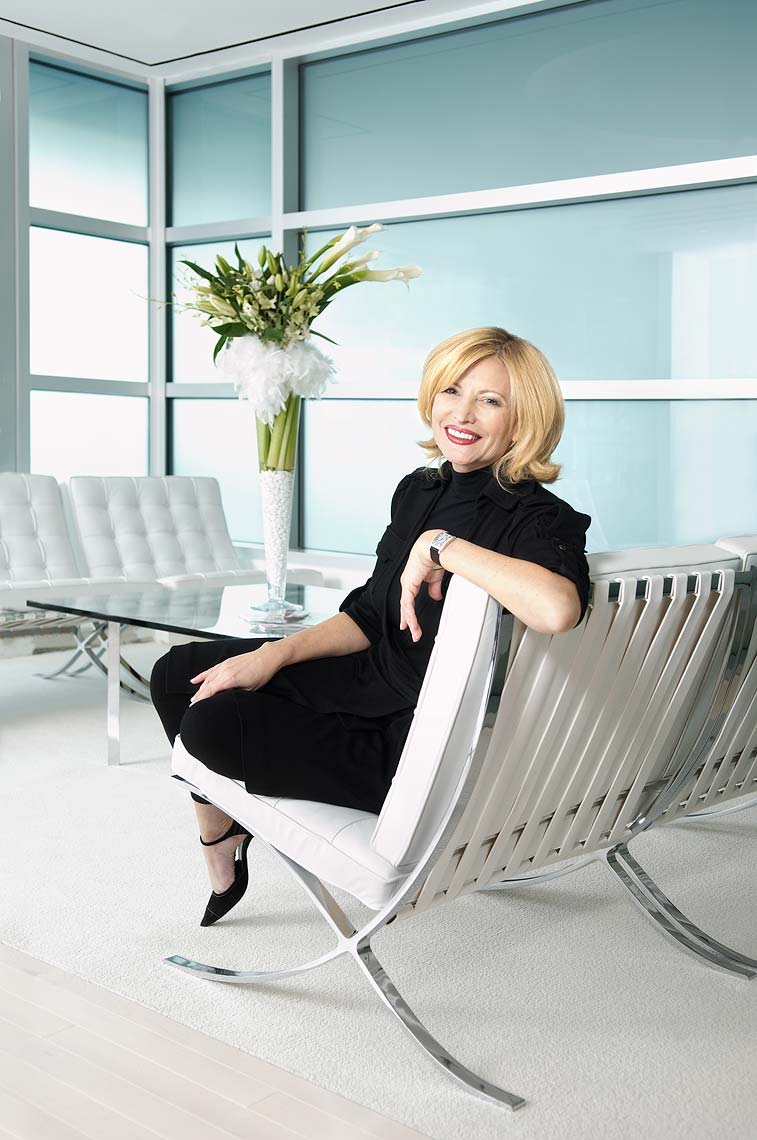 A smiling woman seated in an upscale modern couch
