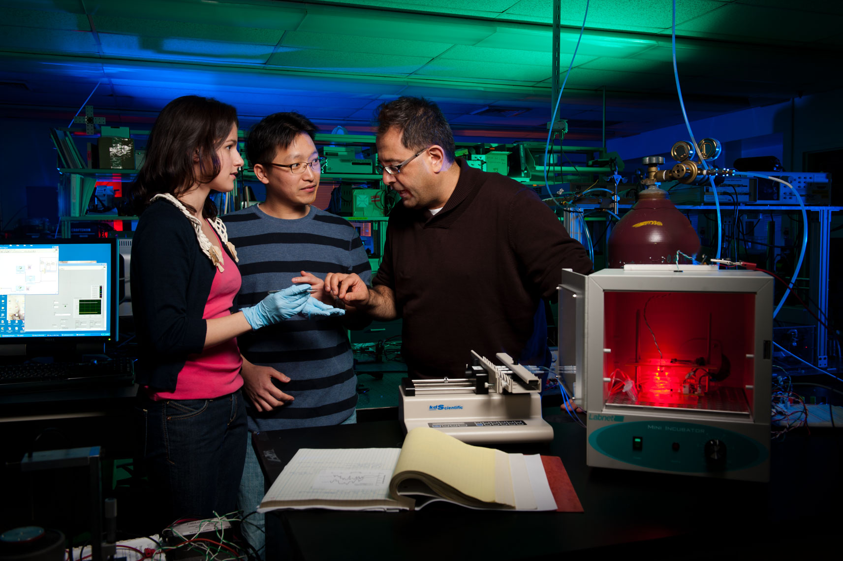 Engineering students working with a professor in a colorful lab