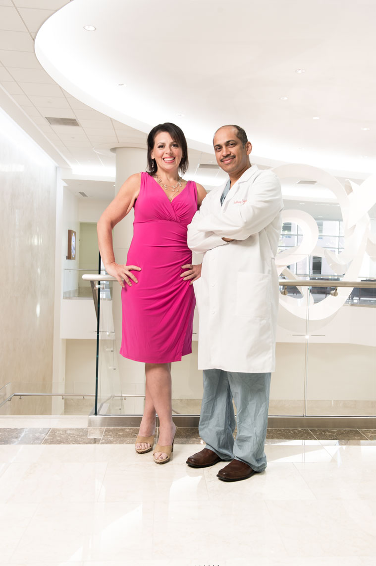 A doctor stands with a weight loss patient in a hospital lobby