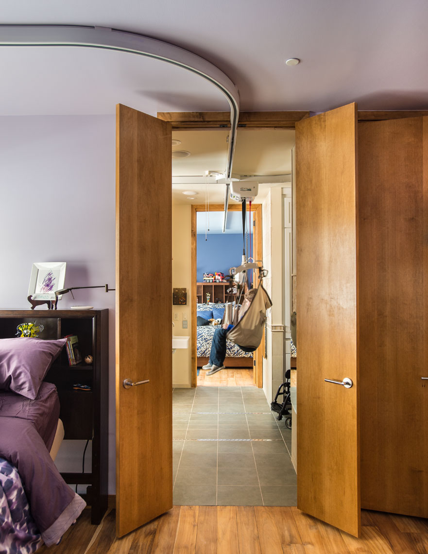 A ceiling gurney system transports a child from room to room in a disability accessible house
