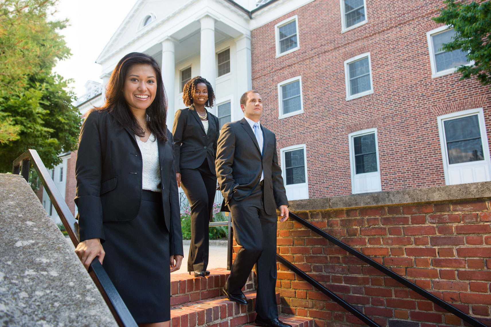 MBA Students walk down a set of stairs on a college campus
