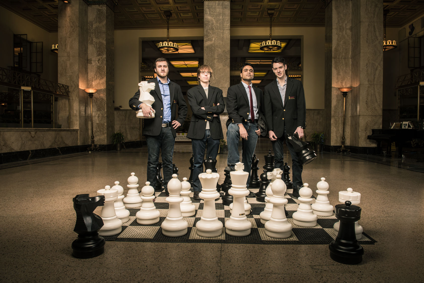 The UMBC Chess Team standing with a giant chessboard