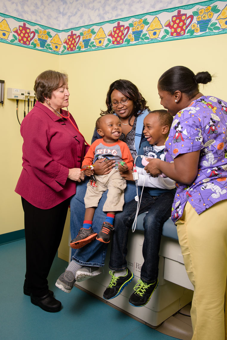 Pediatric doctor Dr. Virginia Keane speaks with patients in an exam room
