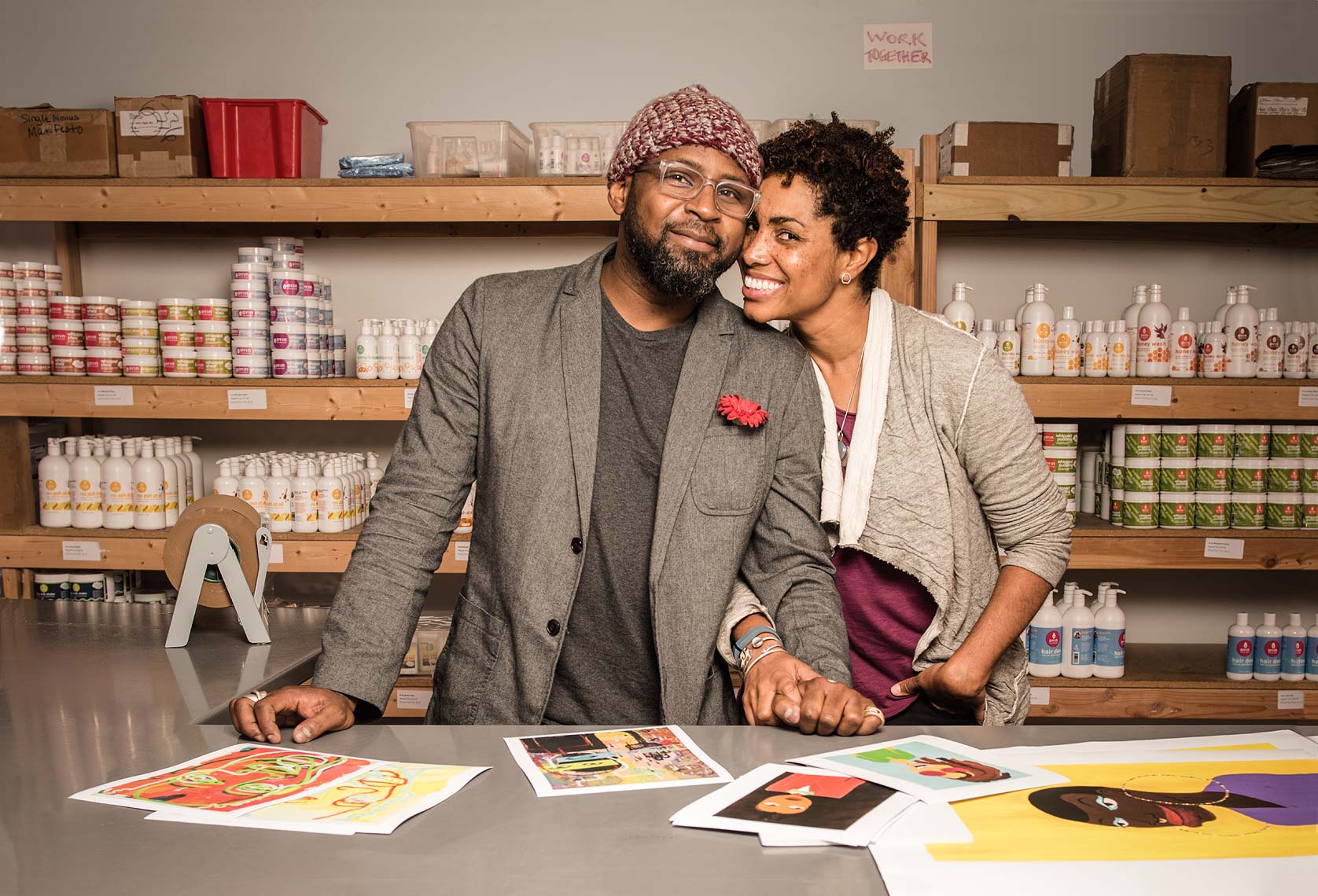 A smiling African-American couple holding hands in a workspace environment