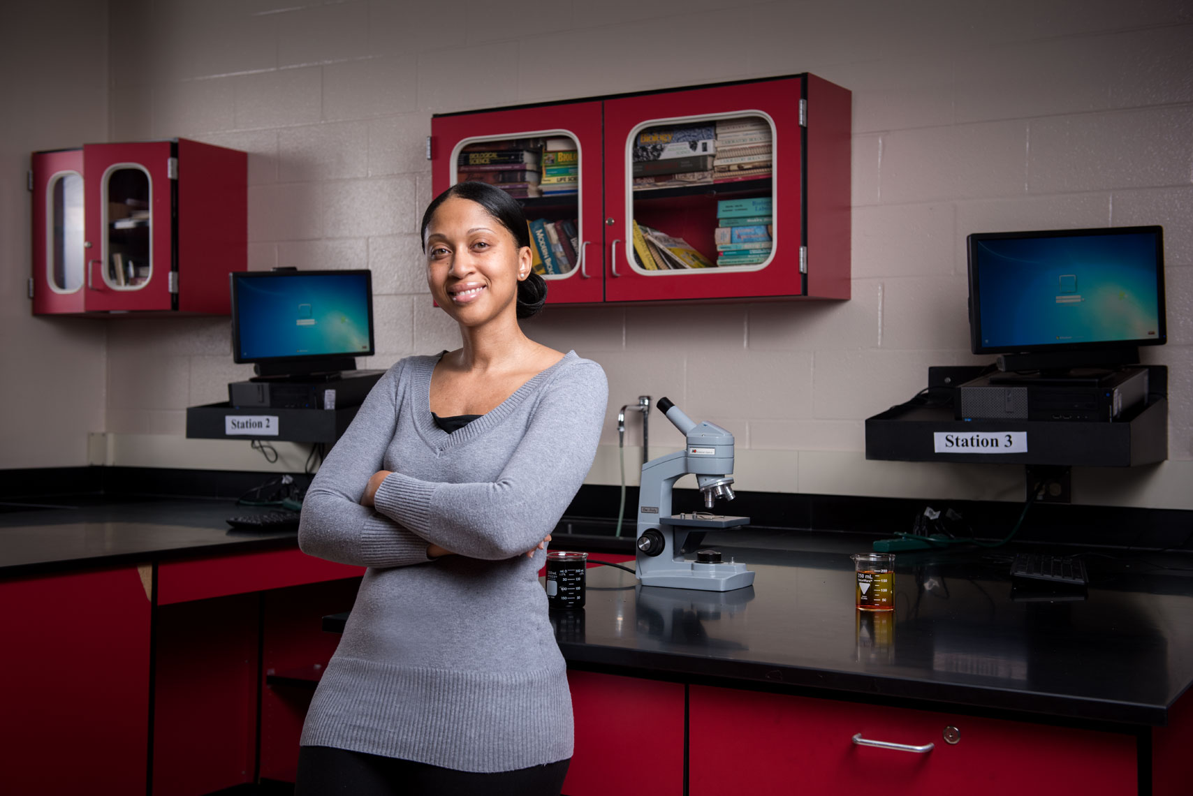 Teacher Shalonda Holt stands in her science classroom next to a microscope