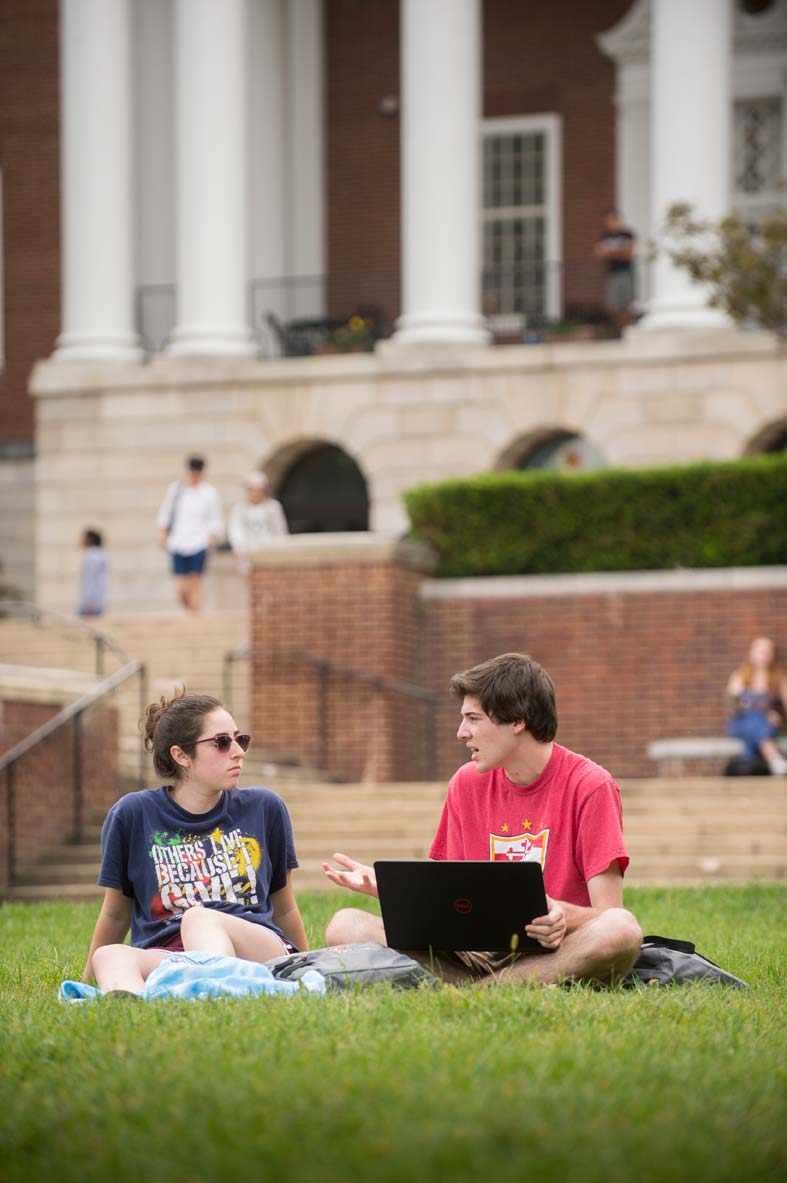 Students studying together on the lawn at a college campus