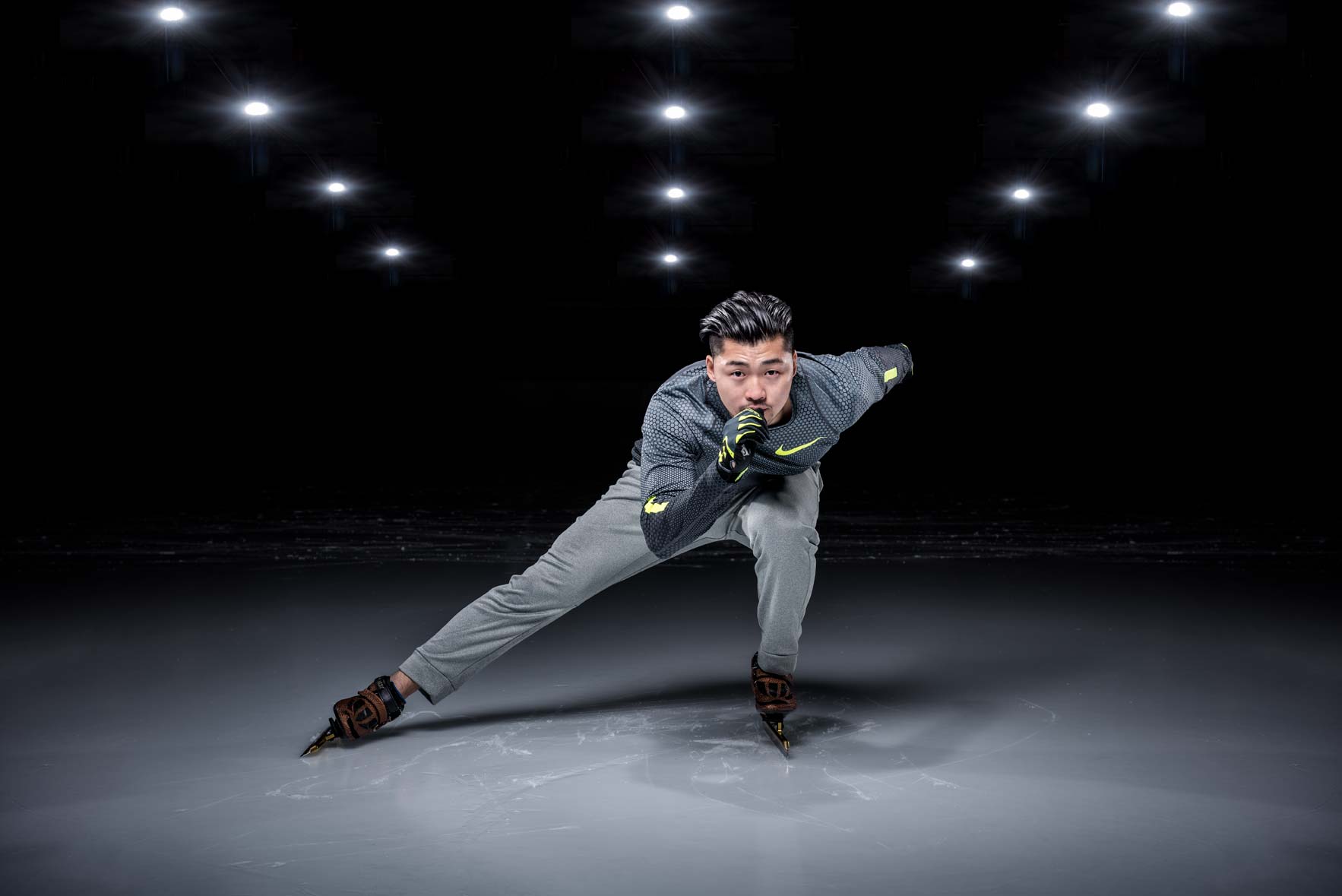 Speed skater Simon Cho gliding on the ice beneath lights