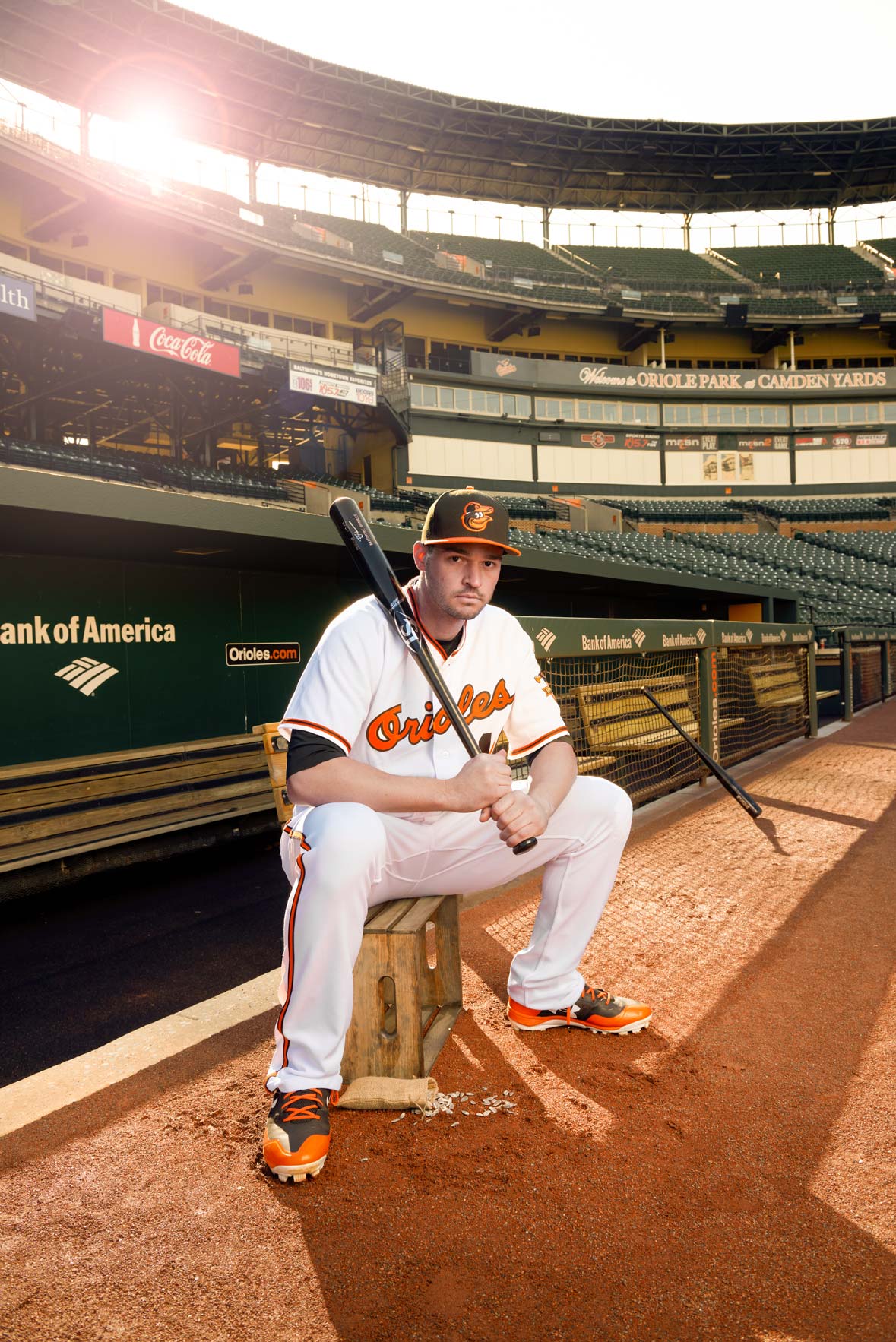 Baltimore Orioles player Trey Mancini seated on a crate on the field at Camden Yards