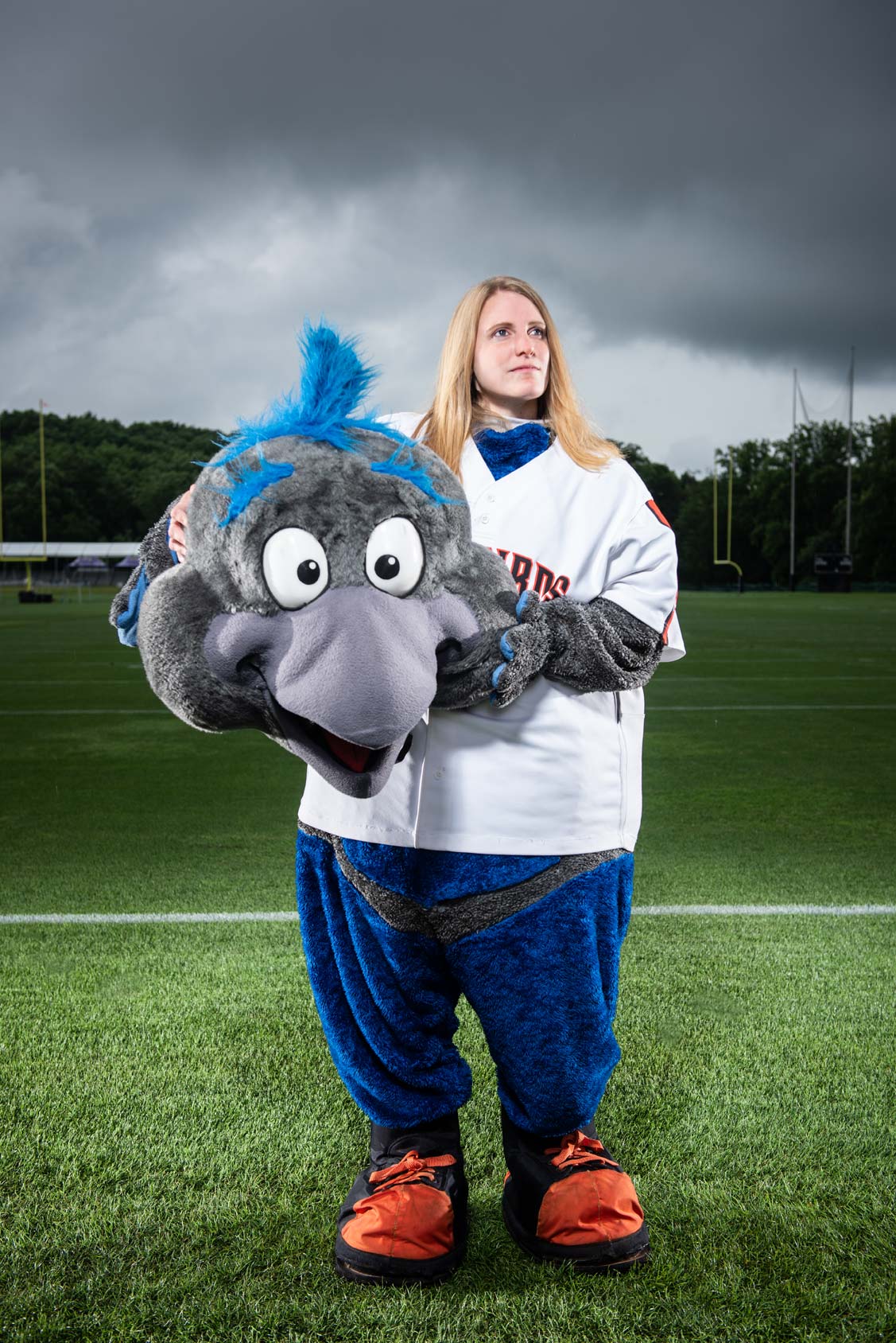Female in a mascot costume with her mascot head in her hands