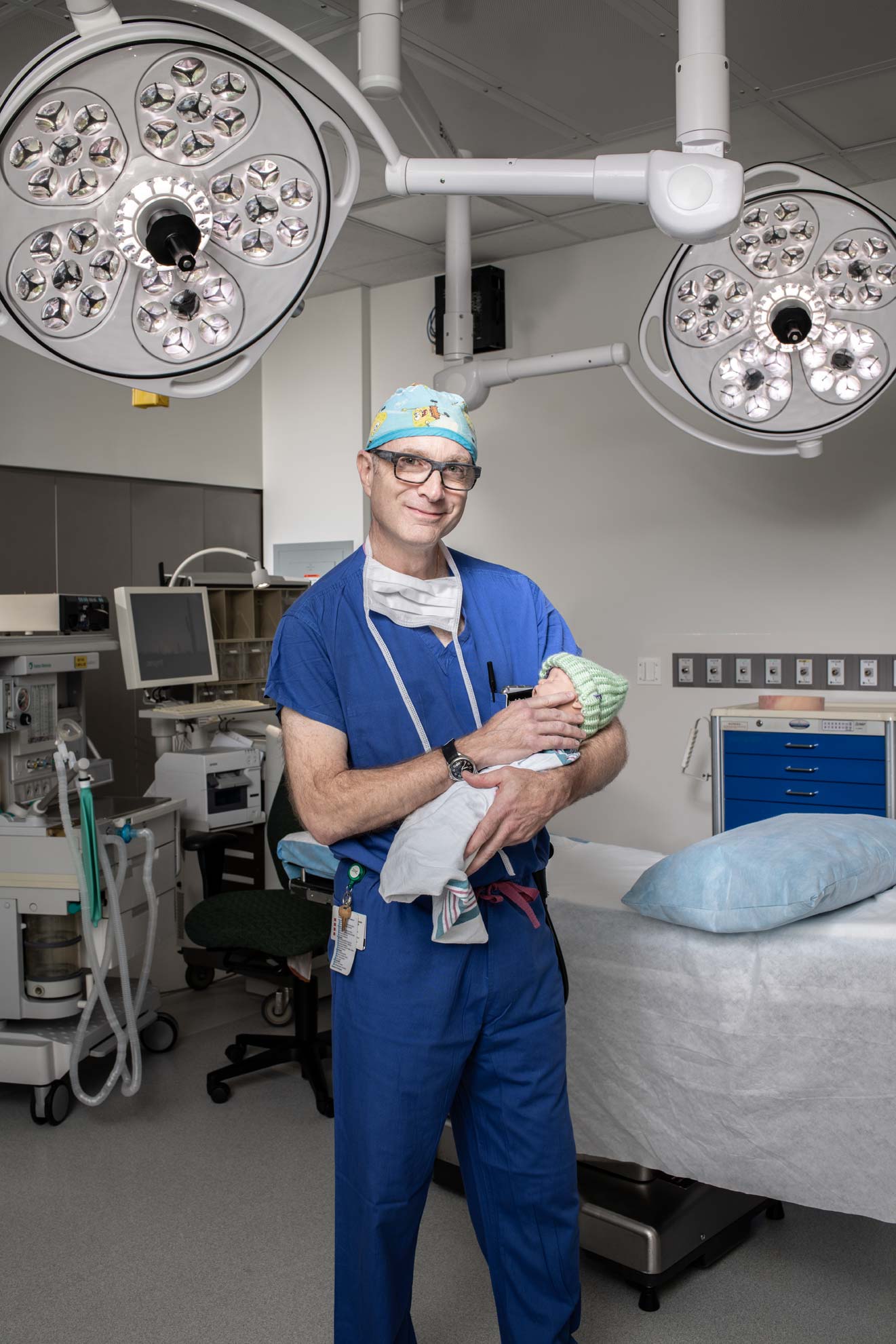 Pediatric anesthesiologist Dr. Jose Dominguez holds a baby in an operating room