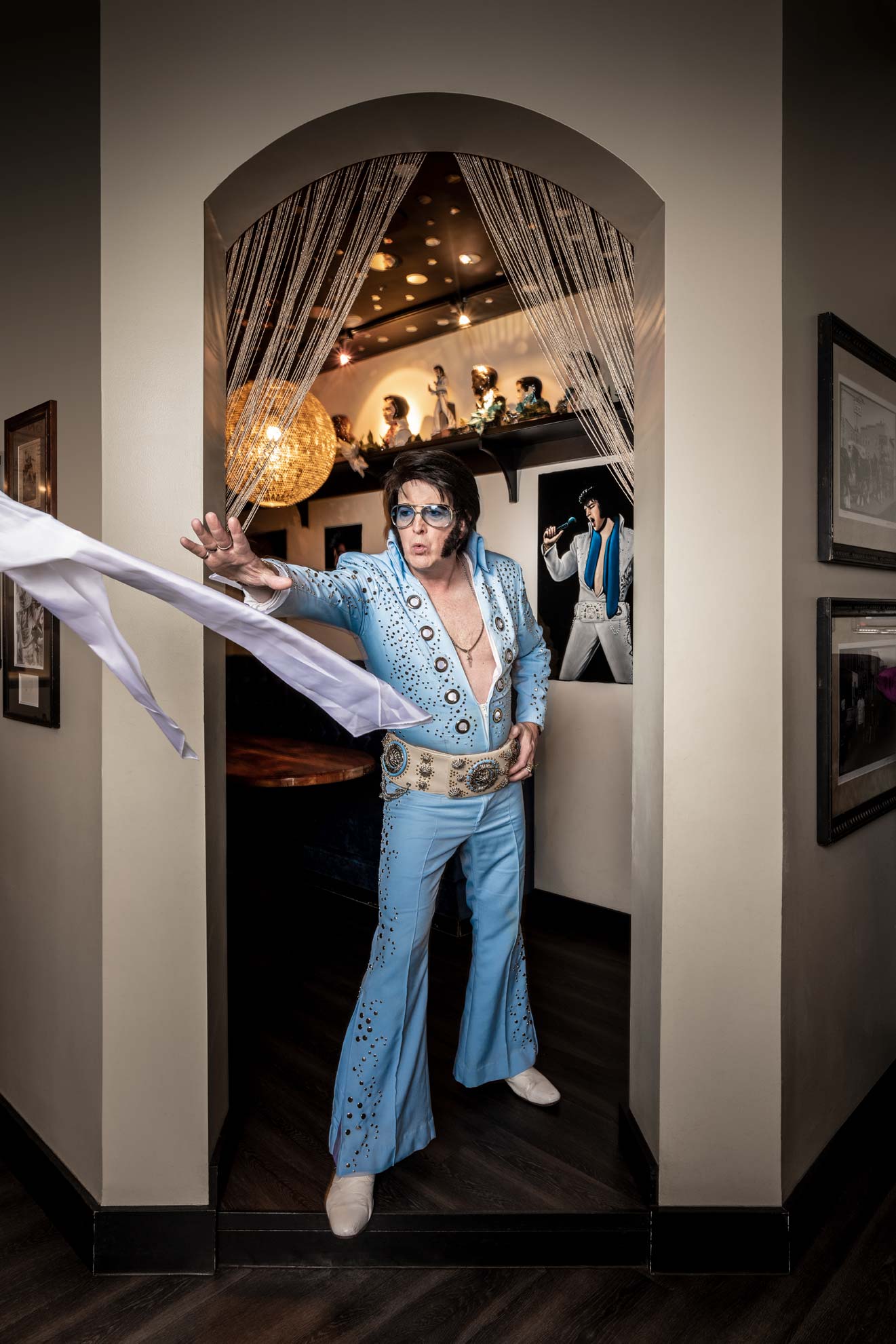 Elvis impersonator Jed Duvall standing in a doorway throwing a scarf