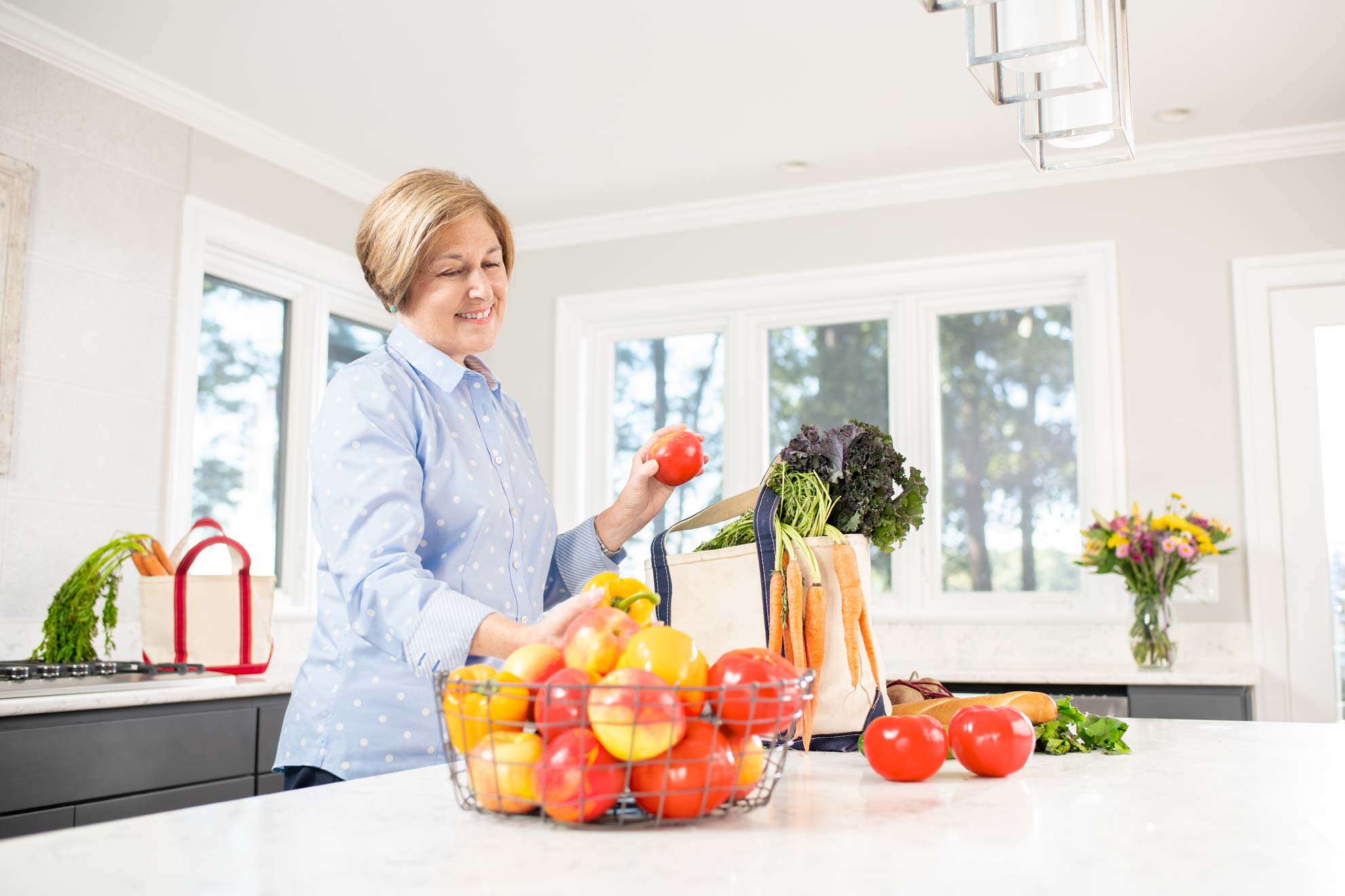 Woman unpacking vegetables from a bag in a her kitchen