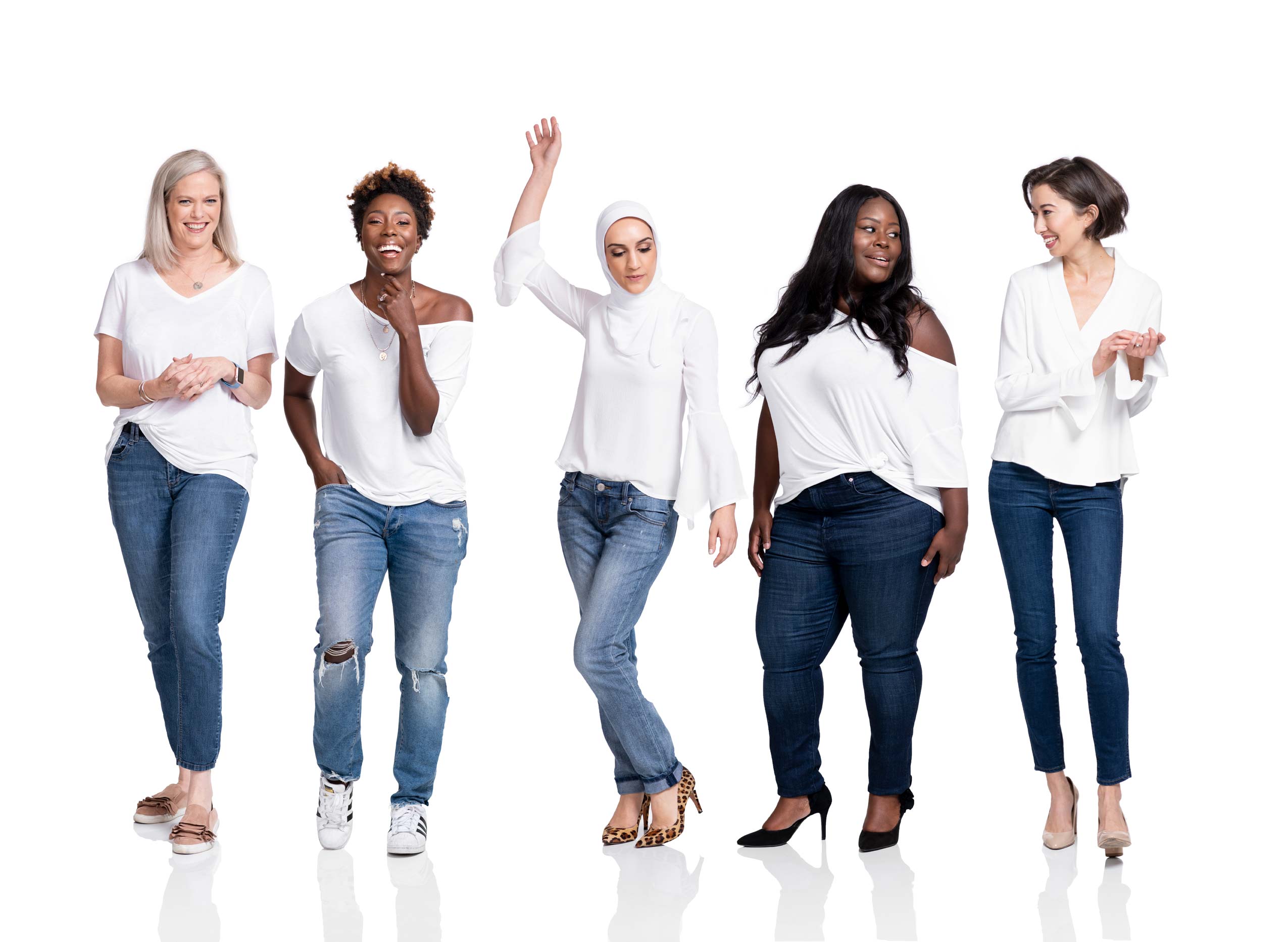 Five multicultural women wearing jeans and white tops on a white background