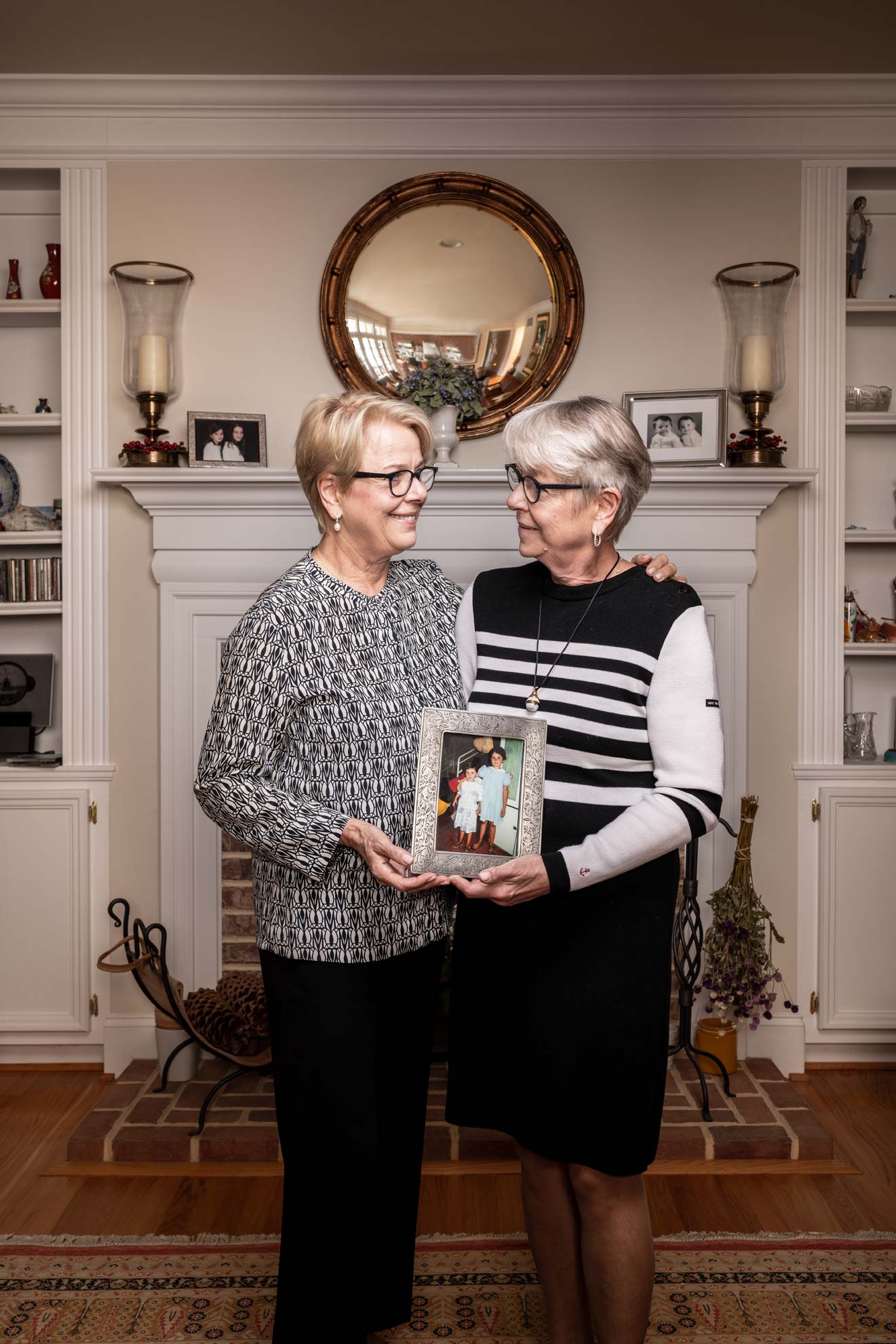 Twin sisters Ileana and Ioana Gheorghiu holding a portrait of their adopted daughters