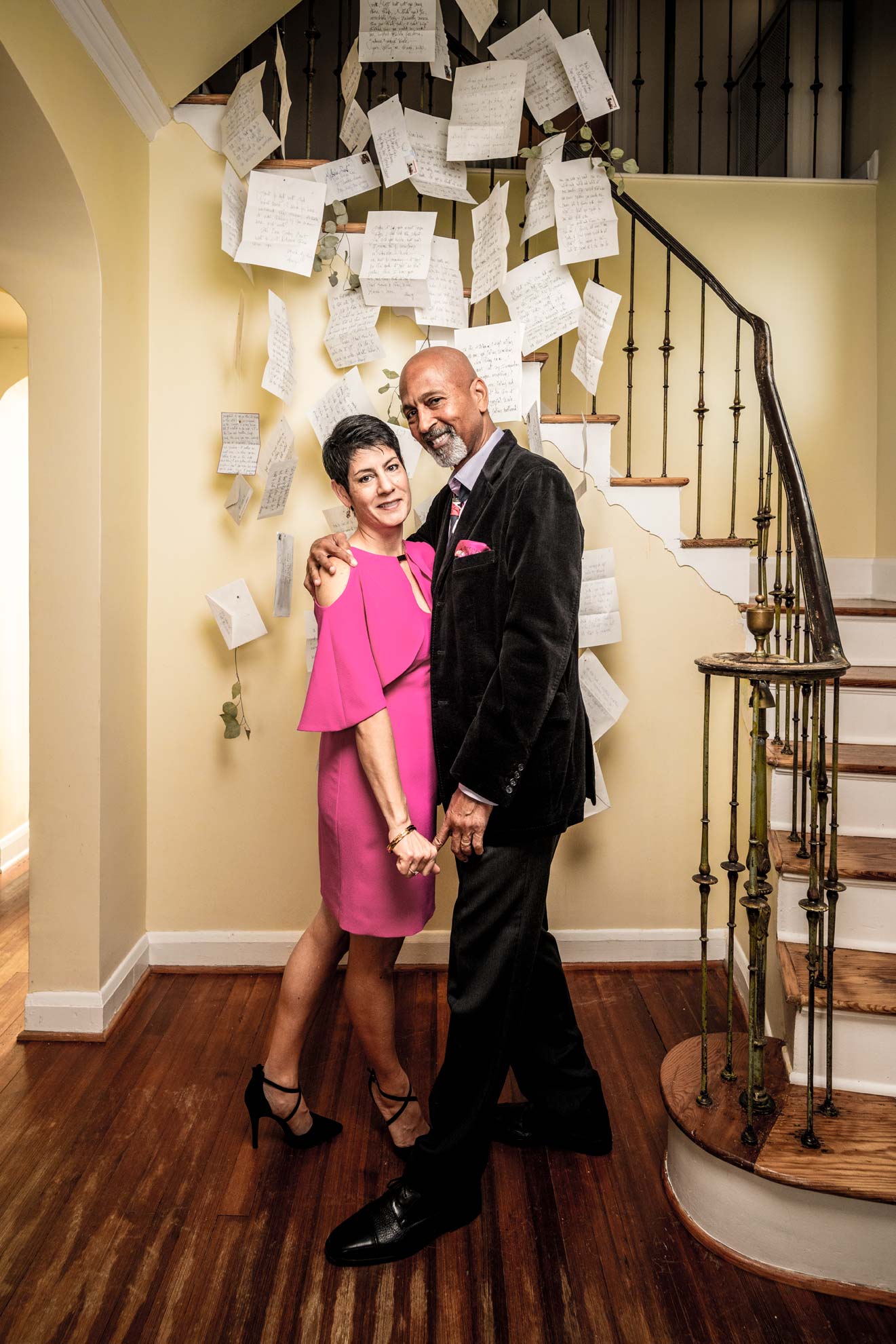 A mixed race couple dancing next to a staircase