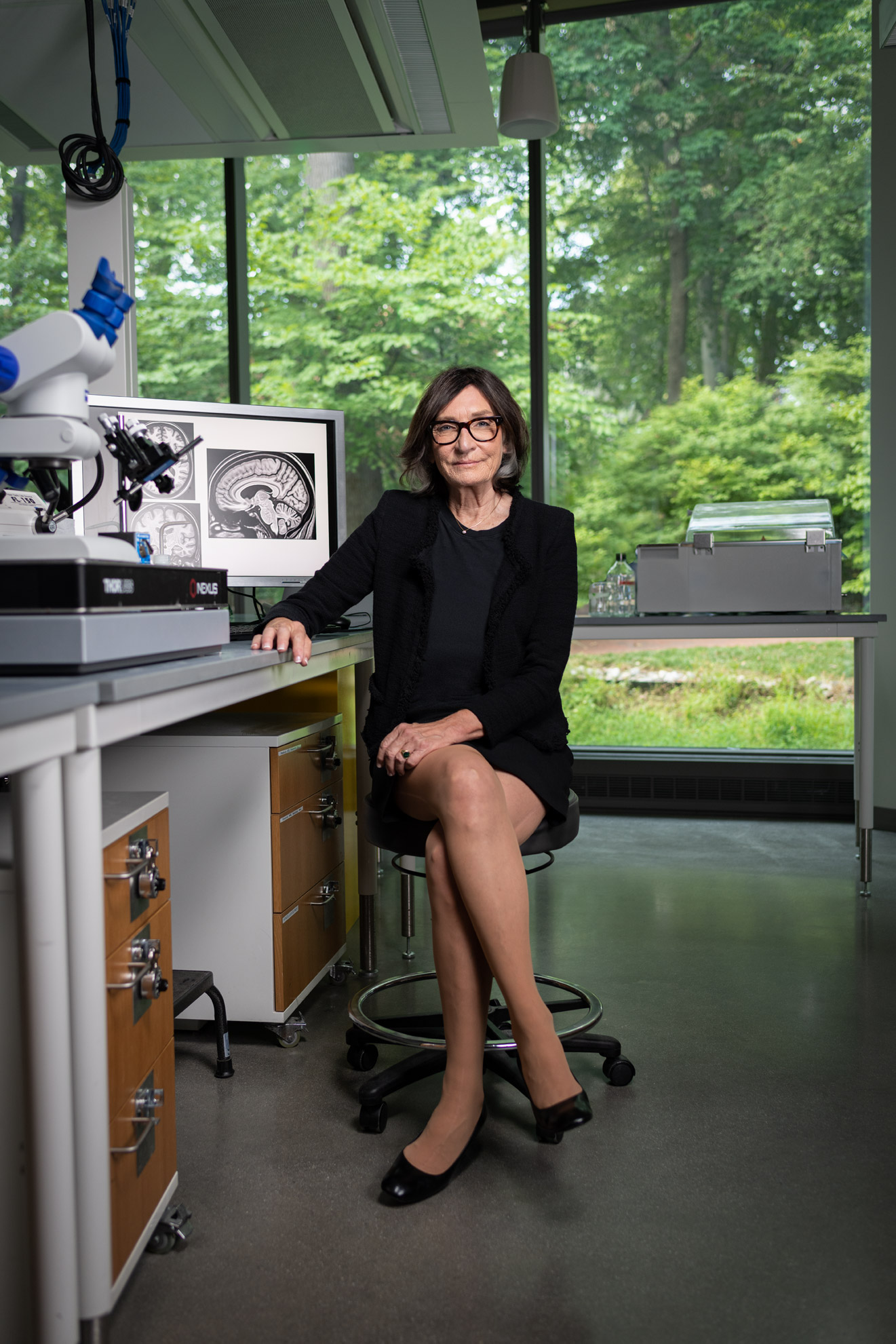 Dr. Michela Gallagher seated in a scientific lab with her legs crossed