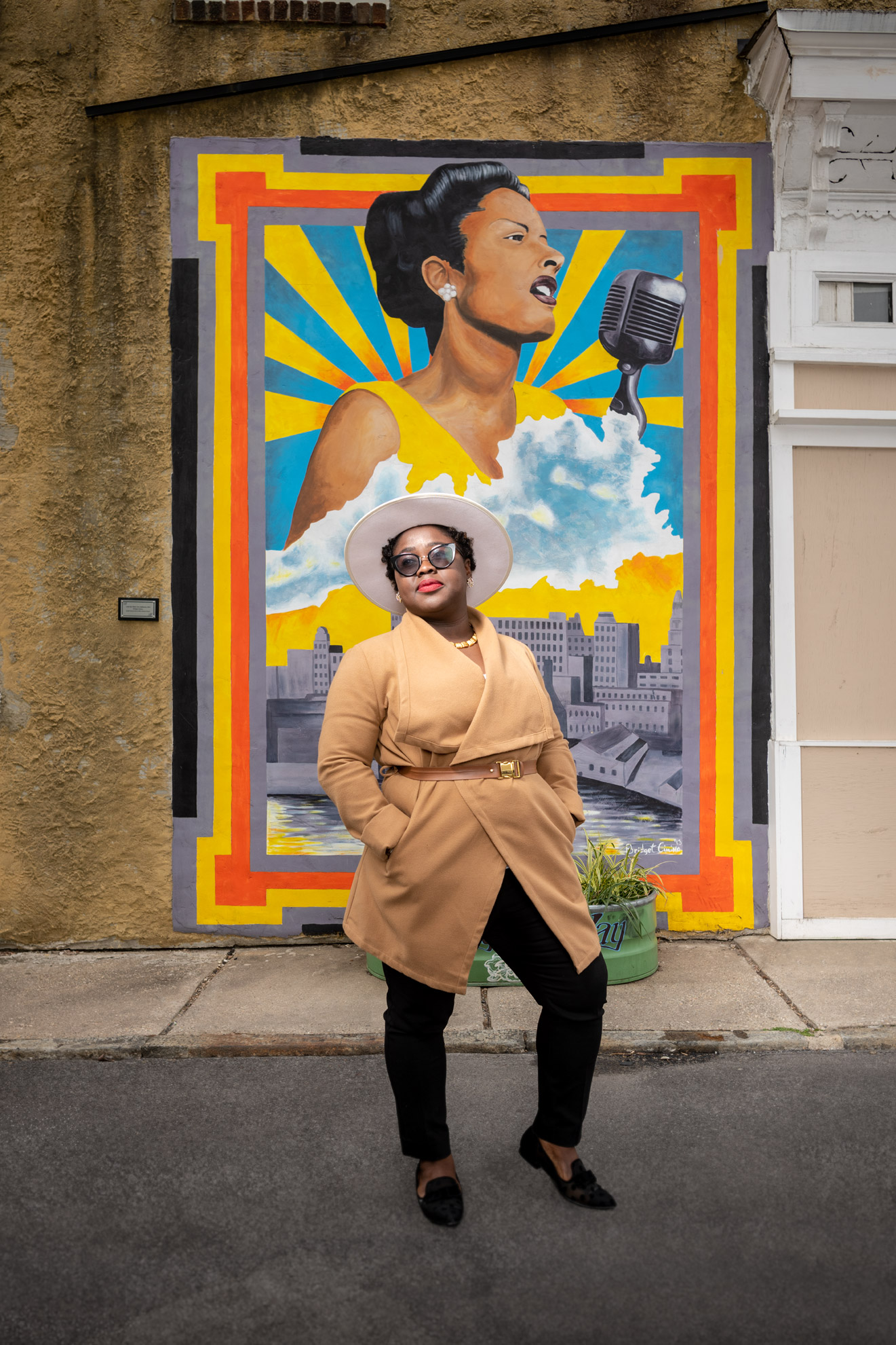Lois Sarfo-Mensah standing in front of the Billie Holiday mural on Lady Day Way in Baltimore