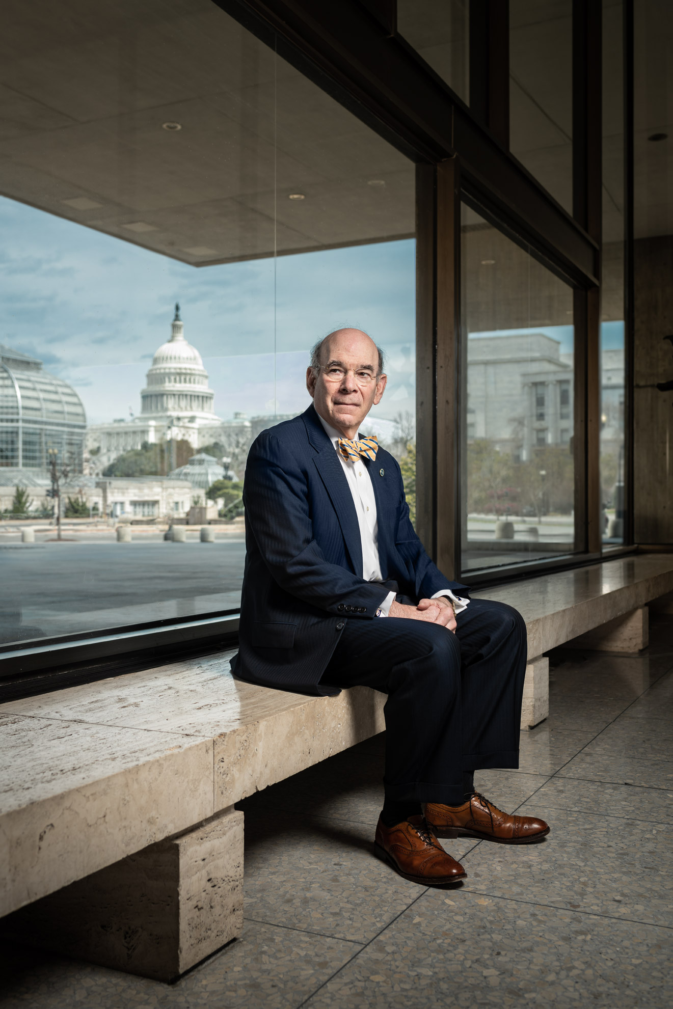 Robert Charrow, General Counsel, seated on a bench in the HHS lobby