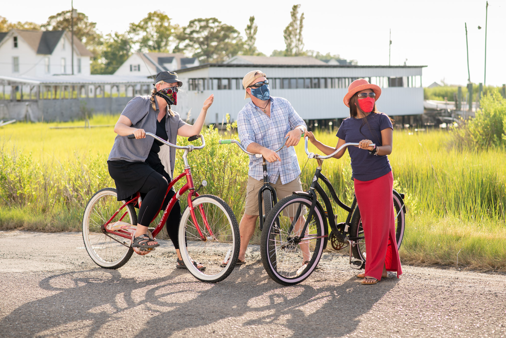 A couple and a tour guide on bicycles wearing masks
