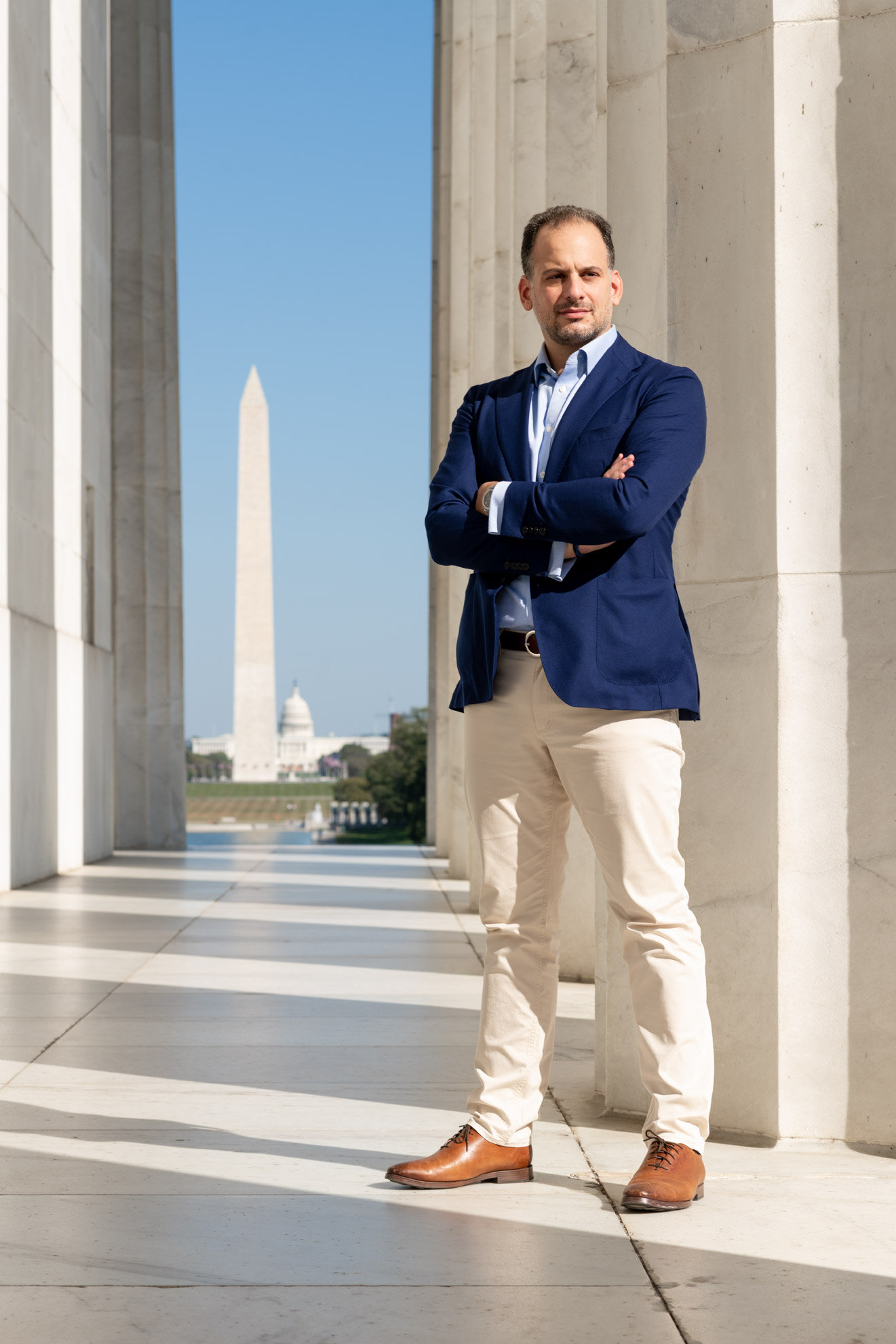 Nikolas Katsimpras standing with his arms folded in front of the Washington Monument